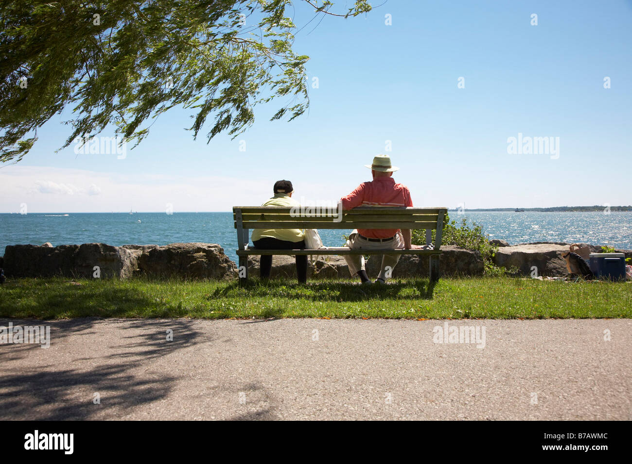 Coppia senior seduta sul banco dal lago Ontario Foto Stock