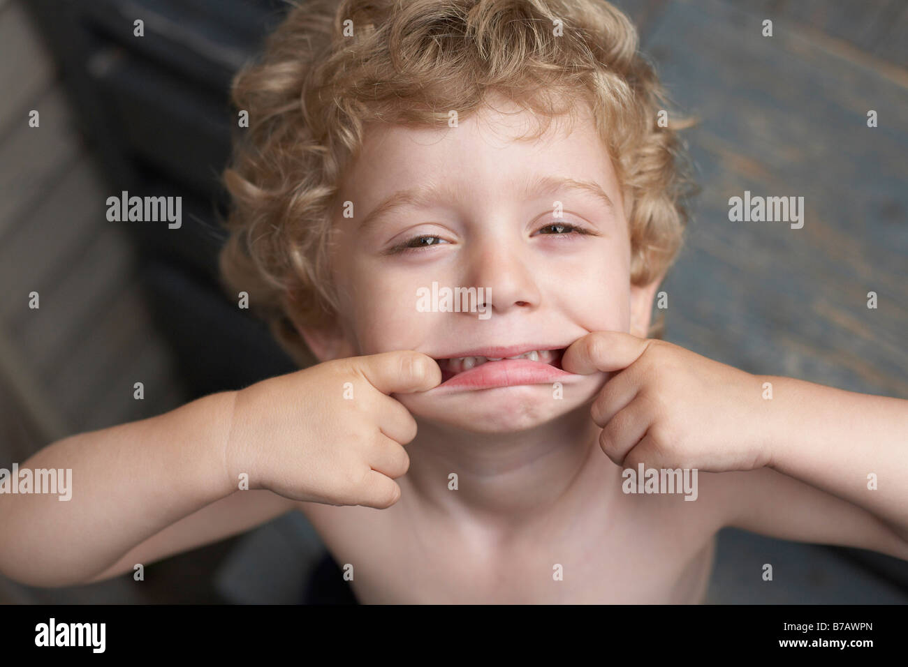 Little Boy rendendo volti Foto Stock