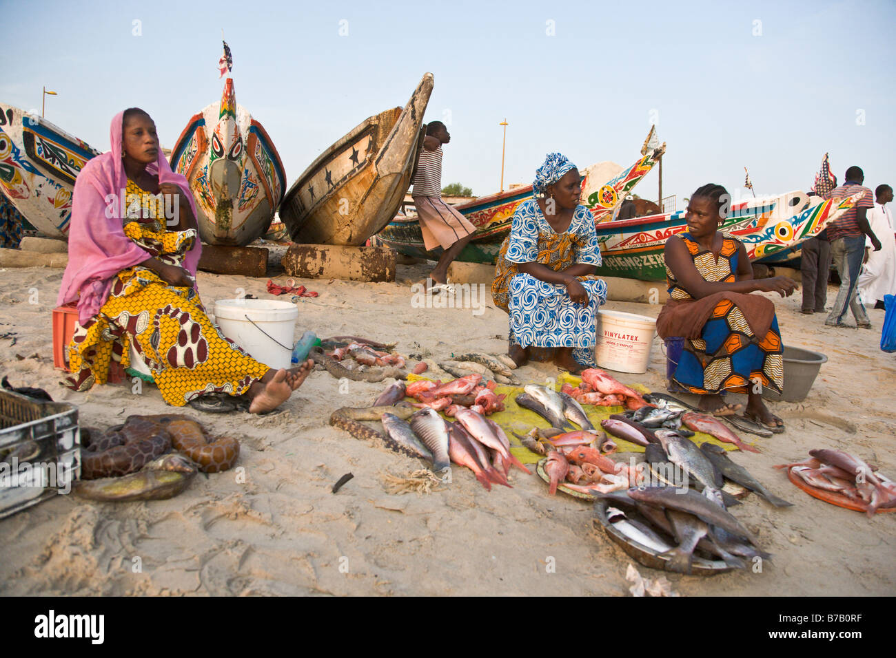 Tre Fulani donne di Dakar in Senegal vendere pesce in questo beachside mercato del pesce. Foto Stock