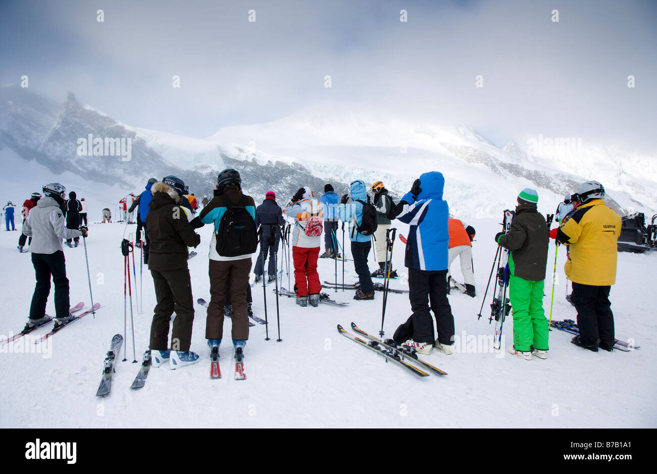 Gli sciatori e gli snowboarder a Allalin stazione superiore preparazione per sci e snowboard, Saas Fee svizzera Foto Stock