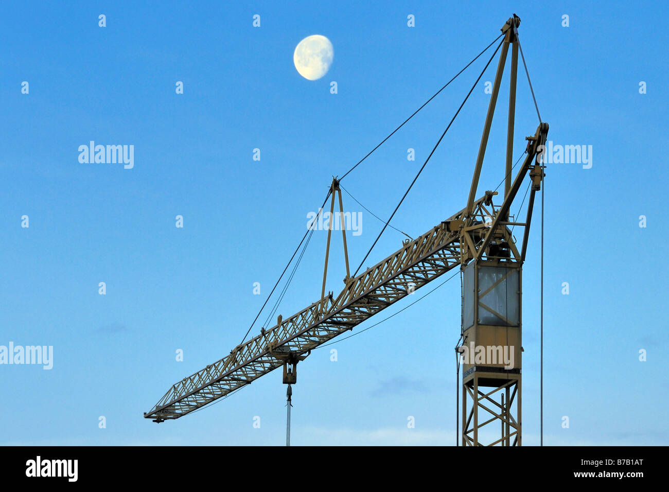 Luna di mattina su una gru da cantiere che simboleggiano il costante cambiamento intorno a noi Foto Stock