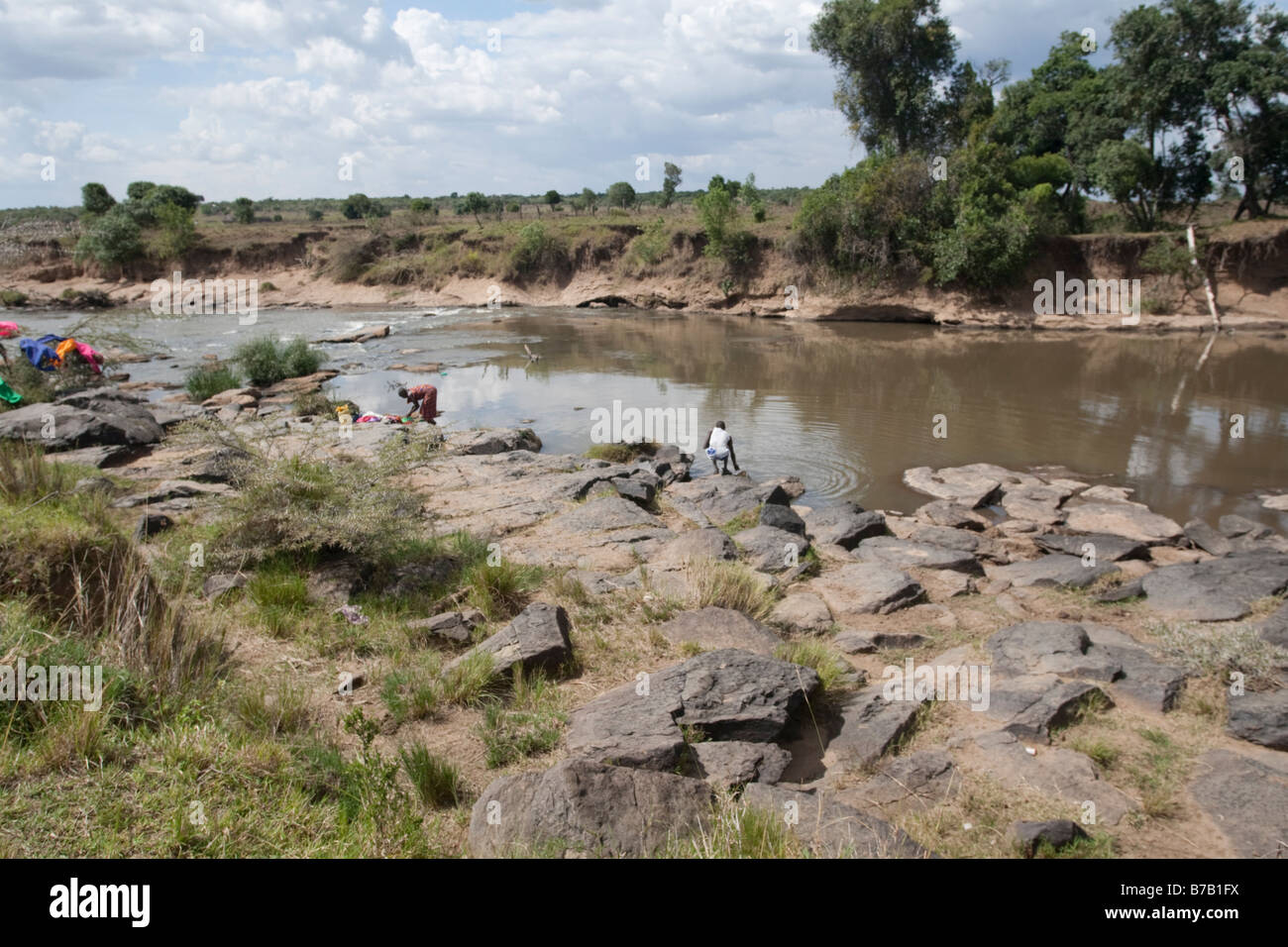 Masai donna lavando vestiti fiume Mara Masai Mara riserva nord Kenya Foto Stock
