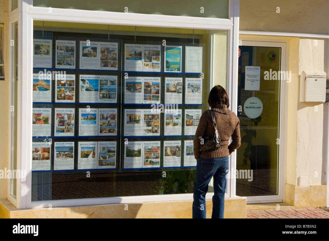 La donna la navigazione nella finestra di agenti immobiliari in Mojacar Almeria Spagna Foto Stock