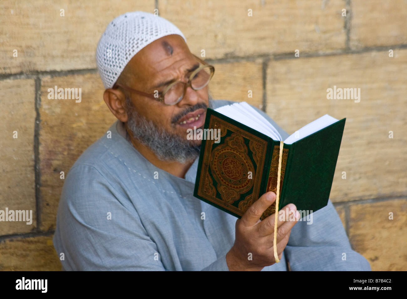 Uomo musulmano la lettura del Corano in dalla Moschea di Al Azhar al Cairo in Egitto Foto Stock