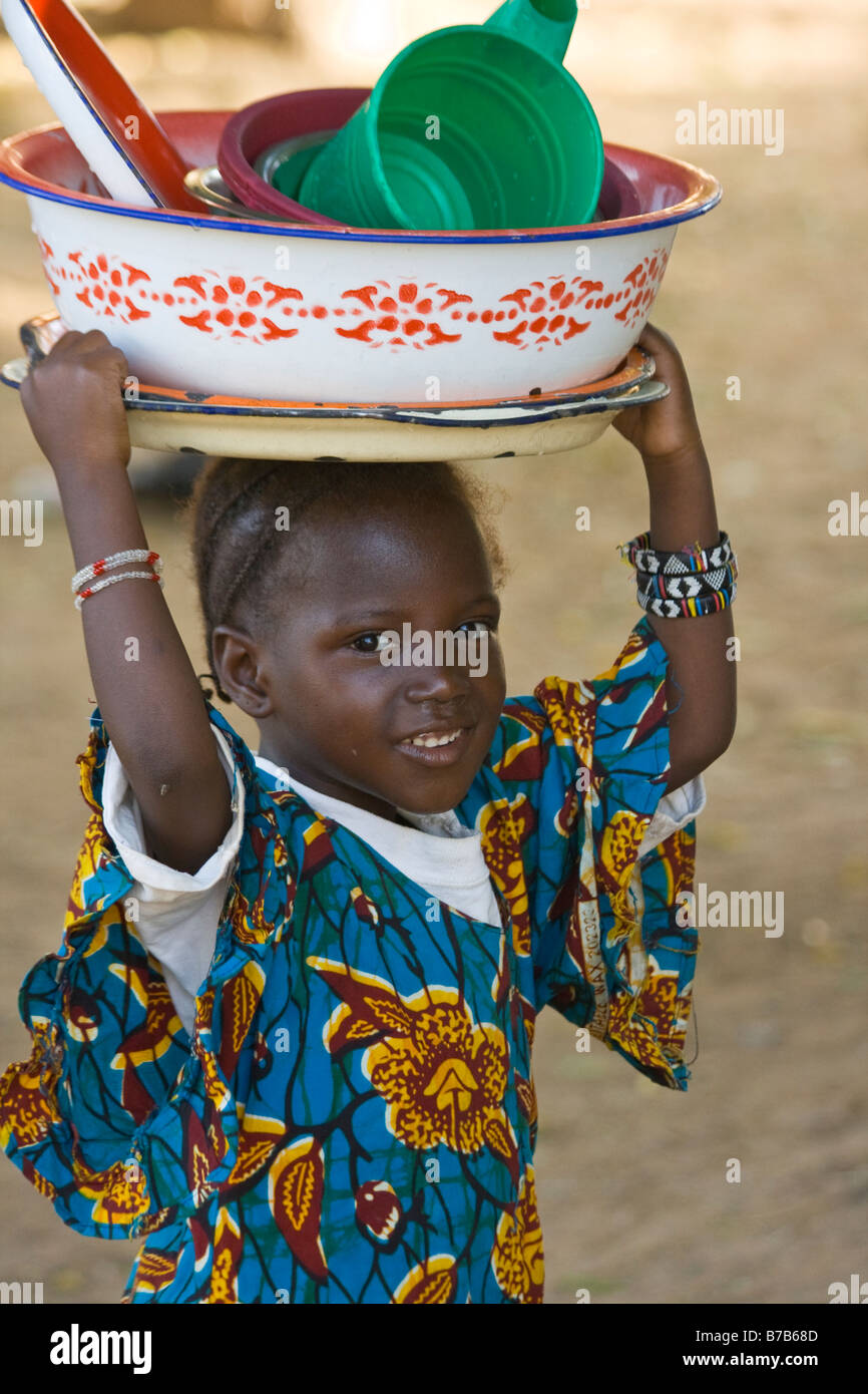 Ragazza giovane che porta un piatti sulla sua testa di Segou in Mali Africa occidentale Foto Stock