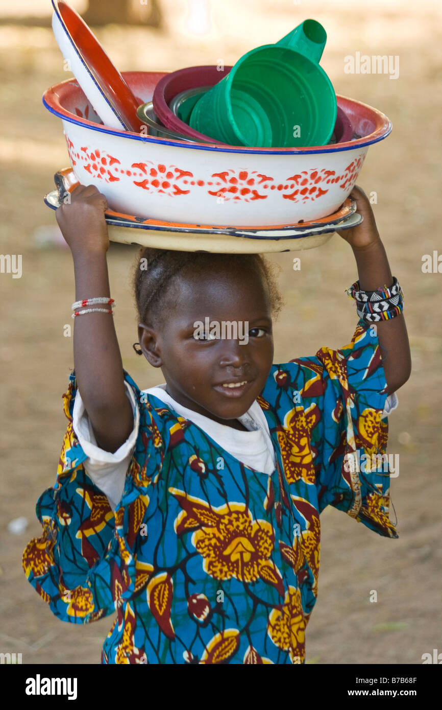 Ragazza giovane che porta un piatti sulla sua testa di Segou in Mali Africa occidentale Foto Stock