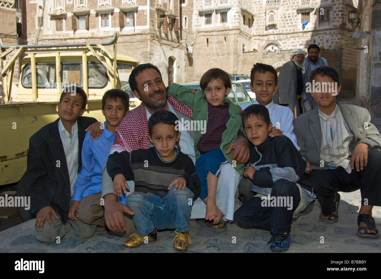 Uomo musulmano con molti bambini nel quartiere del centro storico di Sana a Yemen Foto Stock
