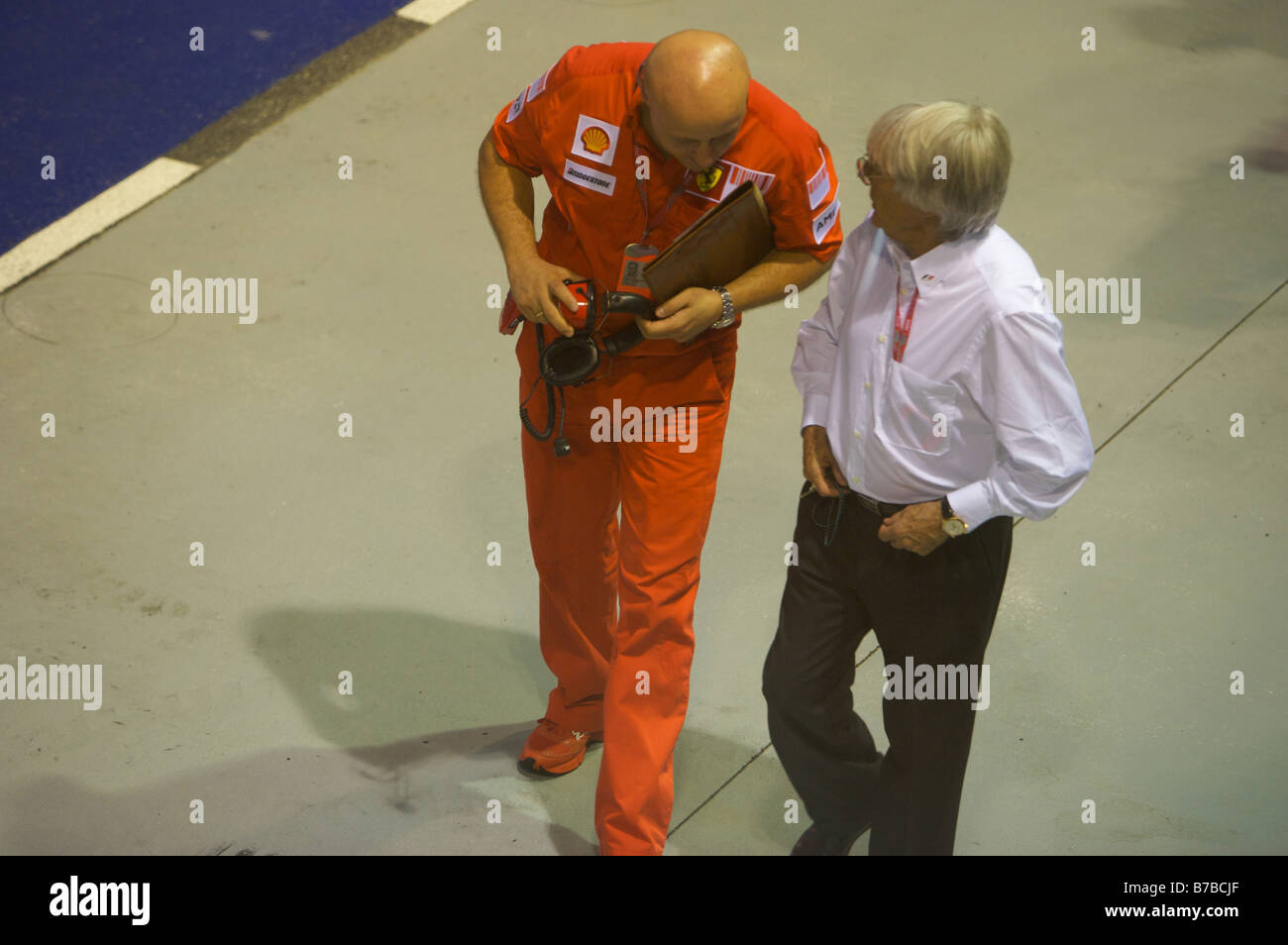 Bernie Ecclestone sulla pit lane con la Ferrari engineer Foto Stock