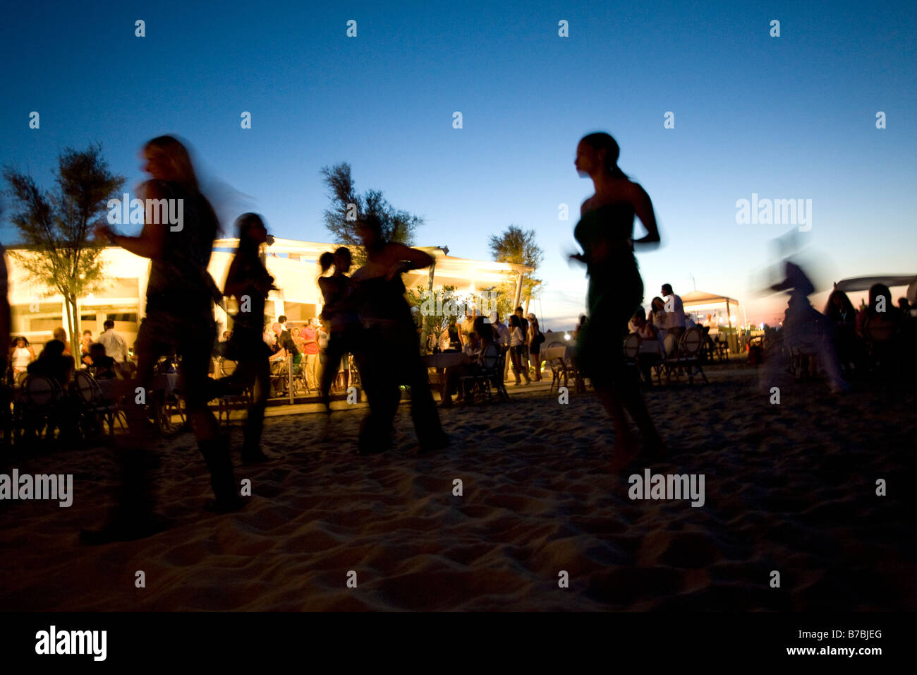 Silhouette di persone aventi party in spiaggia al crepuscolo Foto Stock