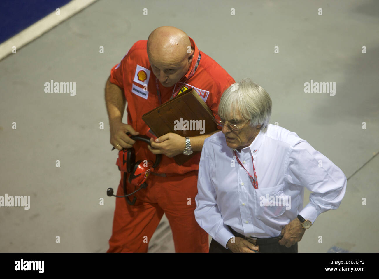 Bernie Ecclestone sulla pit lane con la Ferrari engineer Foto Stock