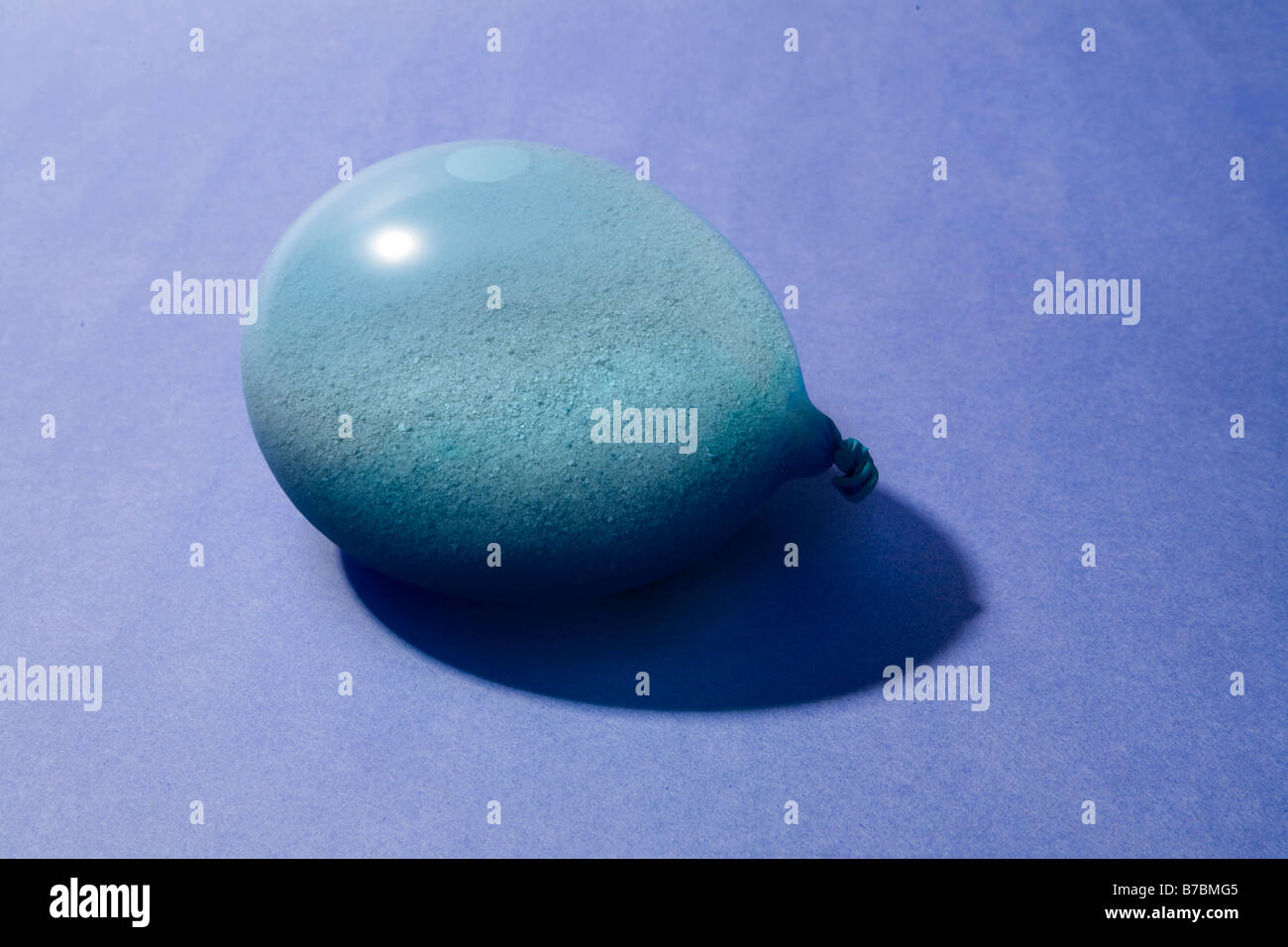 Sabbia blu palloncino riempito su sfondo blu Foto Stock