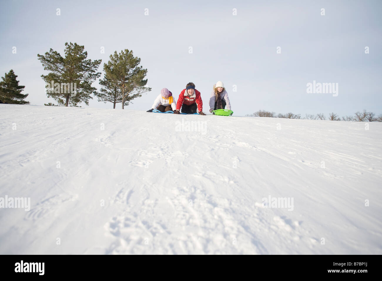 3 bambini (14, 13 e 9 anni) preparare a scorrere giù per la collina, Winnipeg, Canada Foto Stock