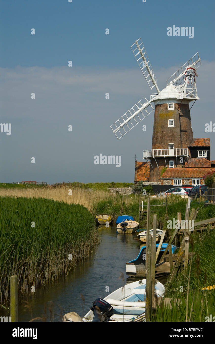 Cley Mill e le paludi, fiume di ingresso e barche, Cley accanto al mare, Norfolk. Regno Unito Foto Stock