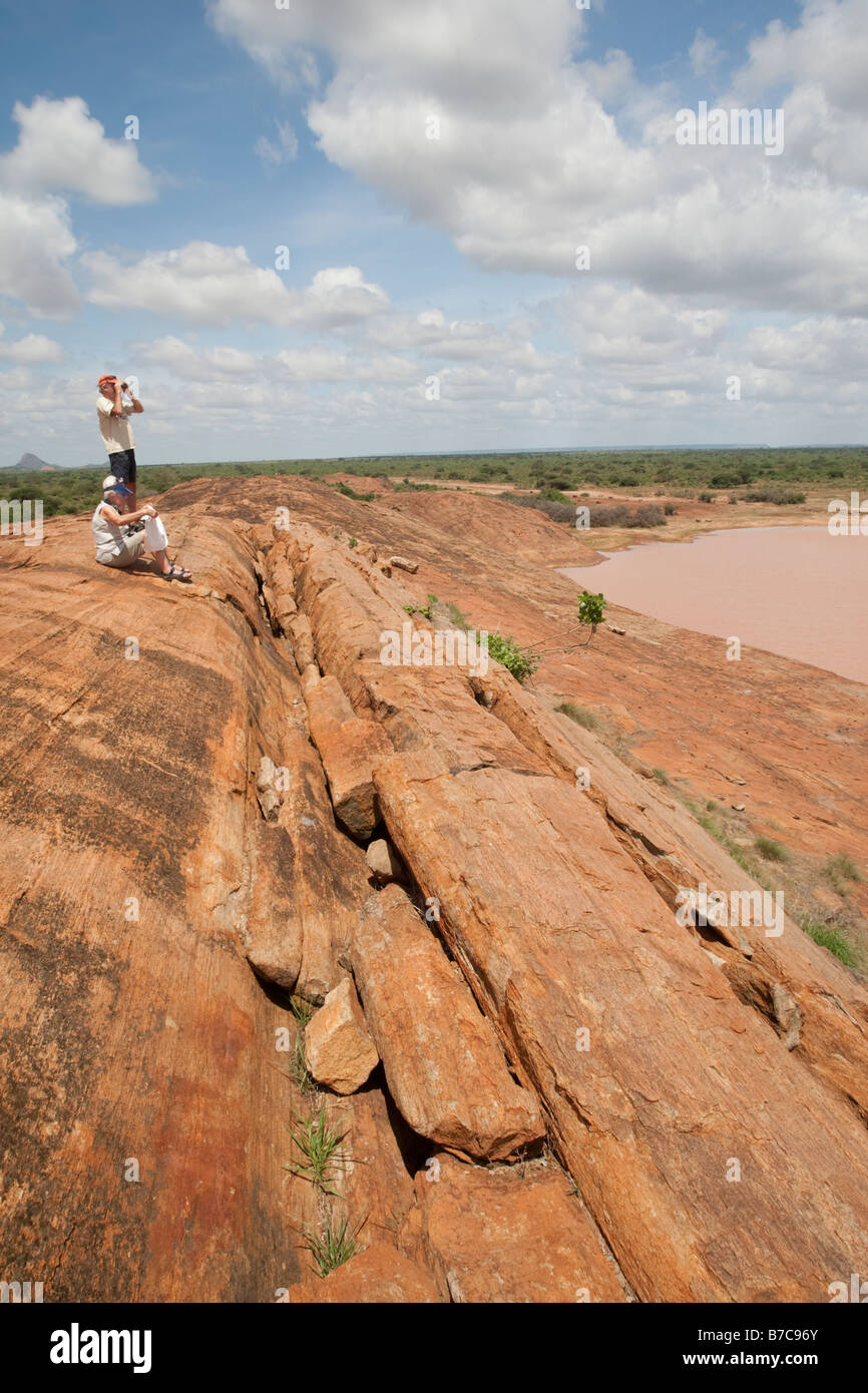 I turisti su roccia Mudunda parco nazionale orientale di Tsavo Kenya Foto Stock