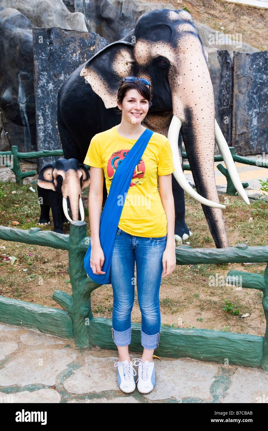 Una giovane donna con un elefante visualizzare sullo sfondo (Sri Lanka) Foto Stock