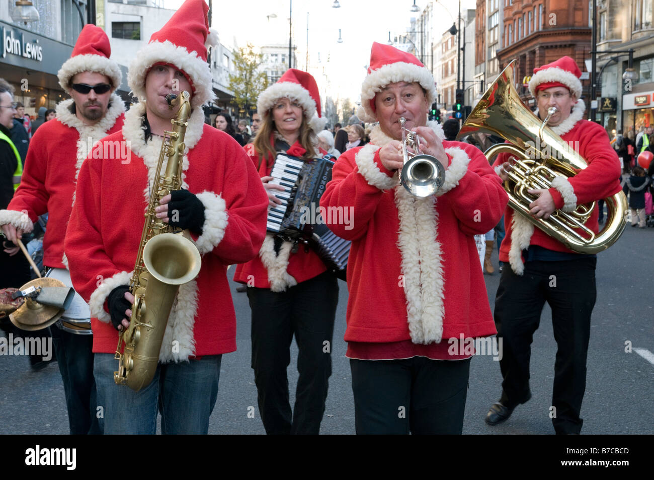 Musicisti vestiti di Babbo Natale abiti giocando su Oxford Street a Natale Londra Inghilterra REGNO UNITO Foto Stock