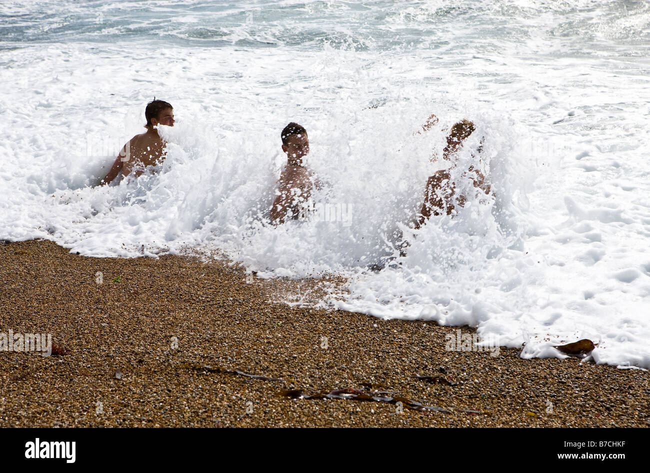 I visitatori potranno gustarsi il surf su una giornata d'estate a Durdle porta su la costa del Dorset, England, Regno Unito Foto Stock
