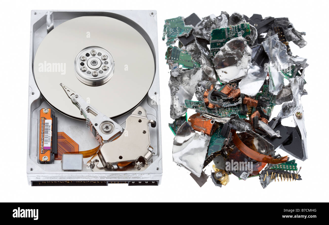 Aprire unità disco rigido del computer seduto accanto a pila di shredded unità disco rigido del computer il materiale su un bianco di sfondo per studio Foto Stock