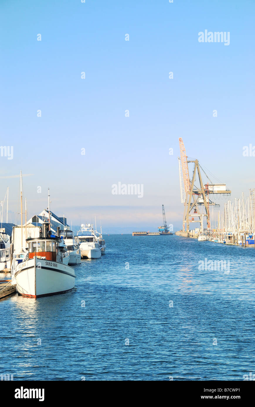 Power Boat con gru portuale e Barge in background Foto Stock