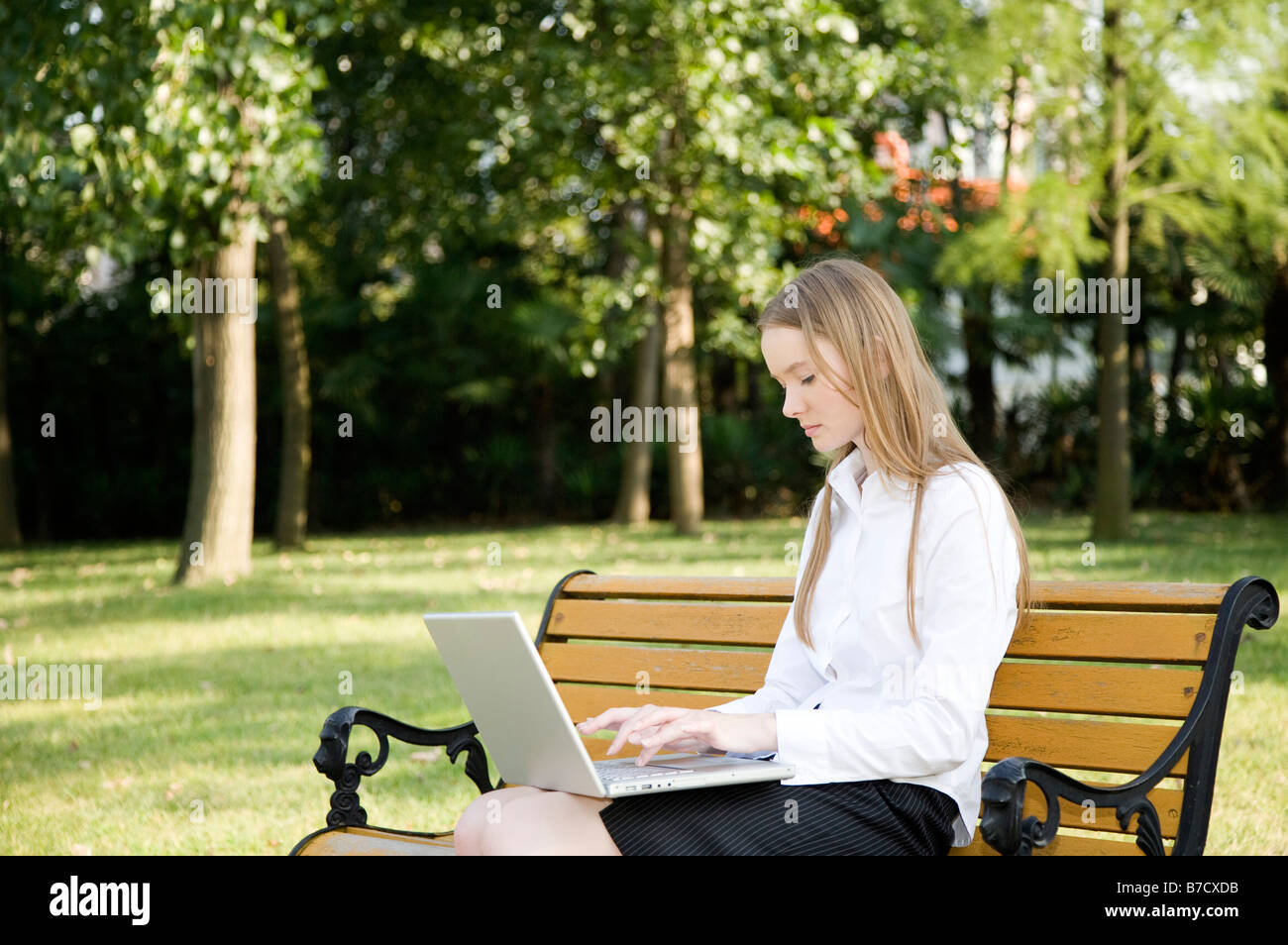 Un business donna seduta sul banco di lavoro e utilizzando il computer portatile Foto Stock