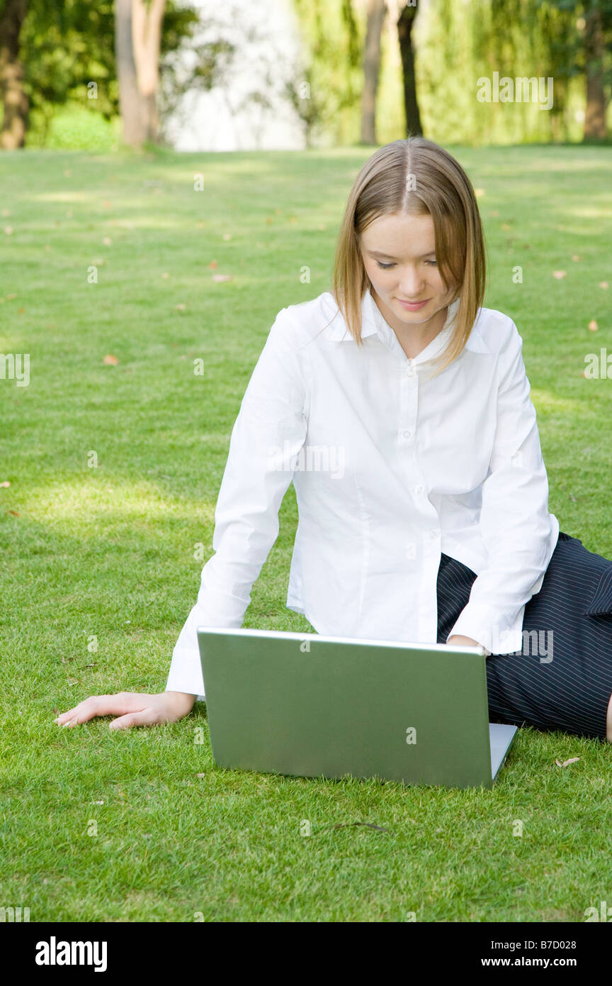Un business donna seduta sul prato e utilizzo di computer portatile Foto Stock