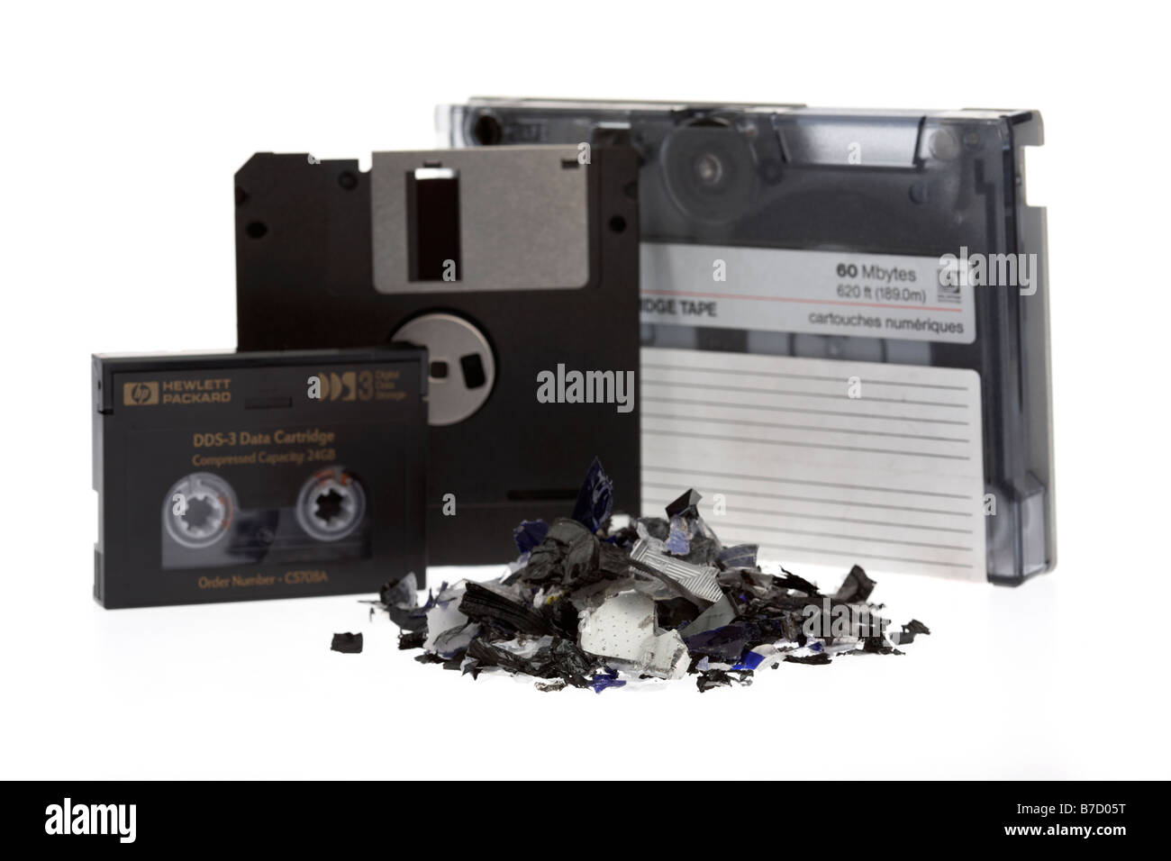Pila di vecchio stile misto di supporti magnetici cartuccia nastro dat dds nastri e dischi floppy su uno sfondo bianco con supporti di trinciato Foto Stock