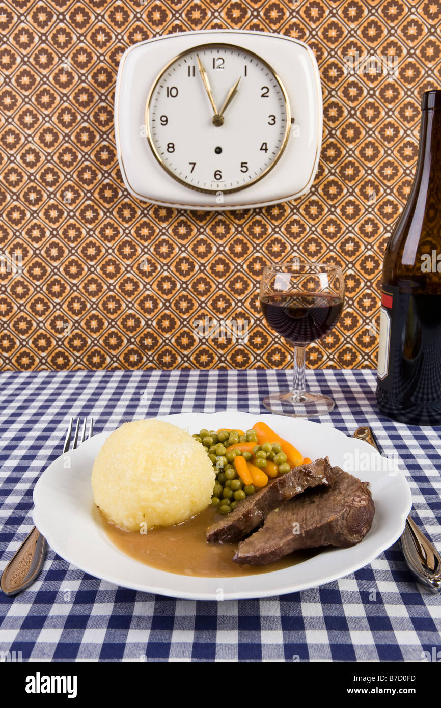 Un piatto di cibo con un bicchiere e una bottiglia di vino Foto Stock