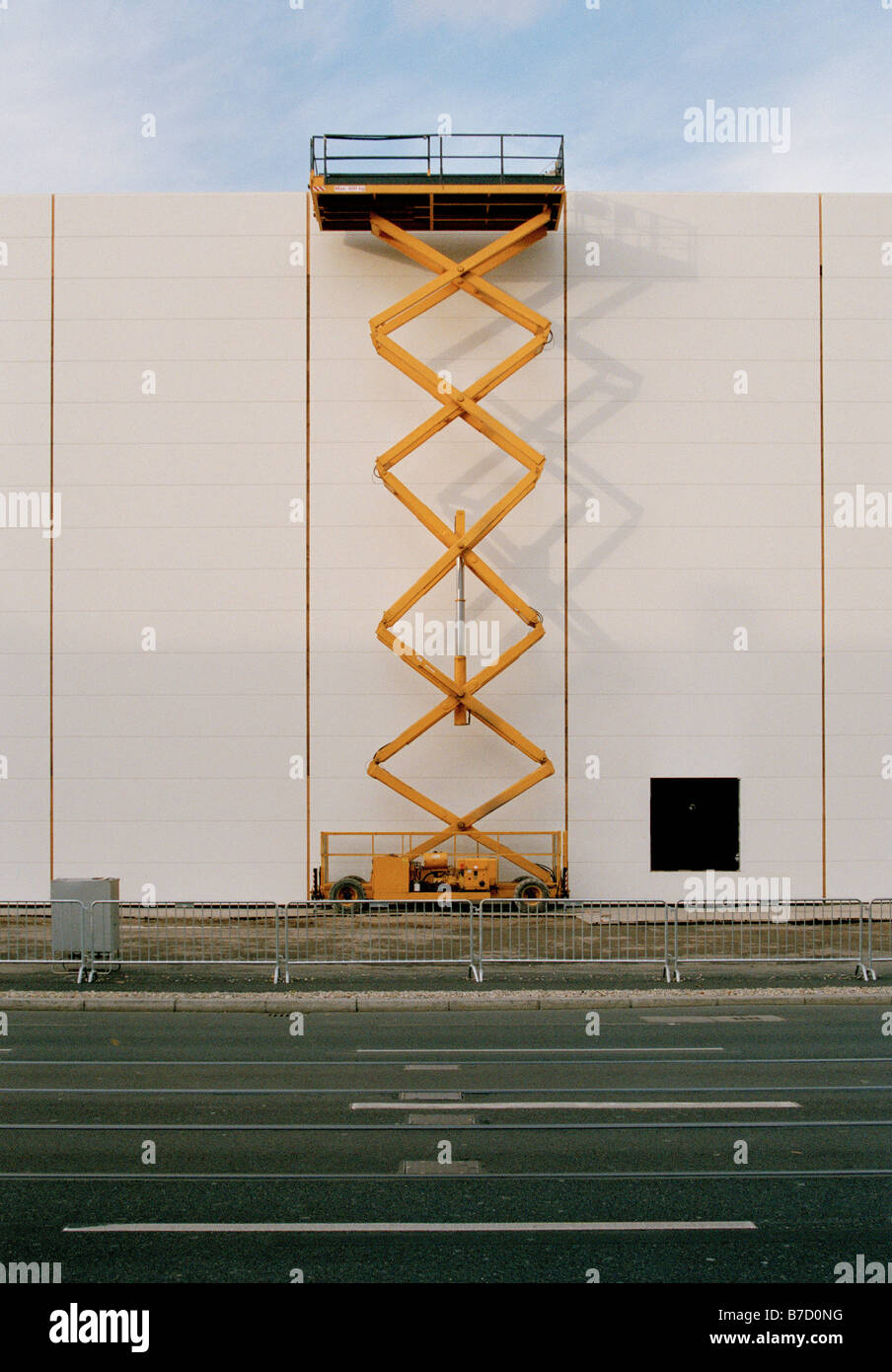 Una piattaforma idraulica sollevata accanto a un edificio Foto Stock