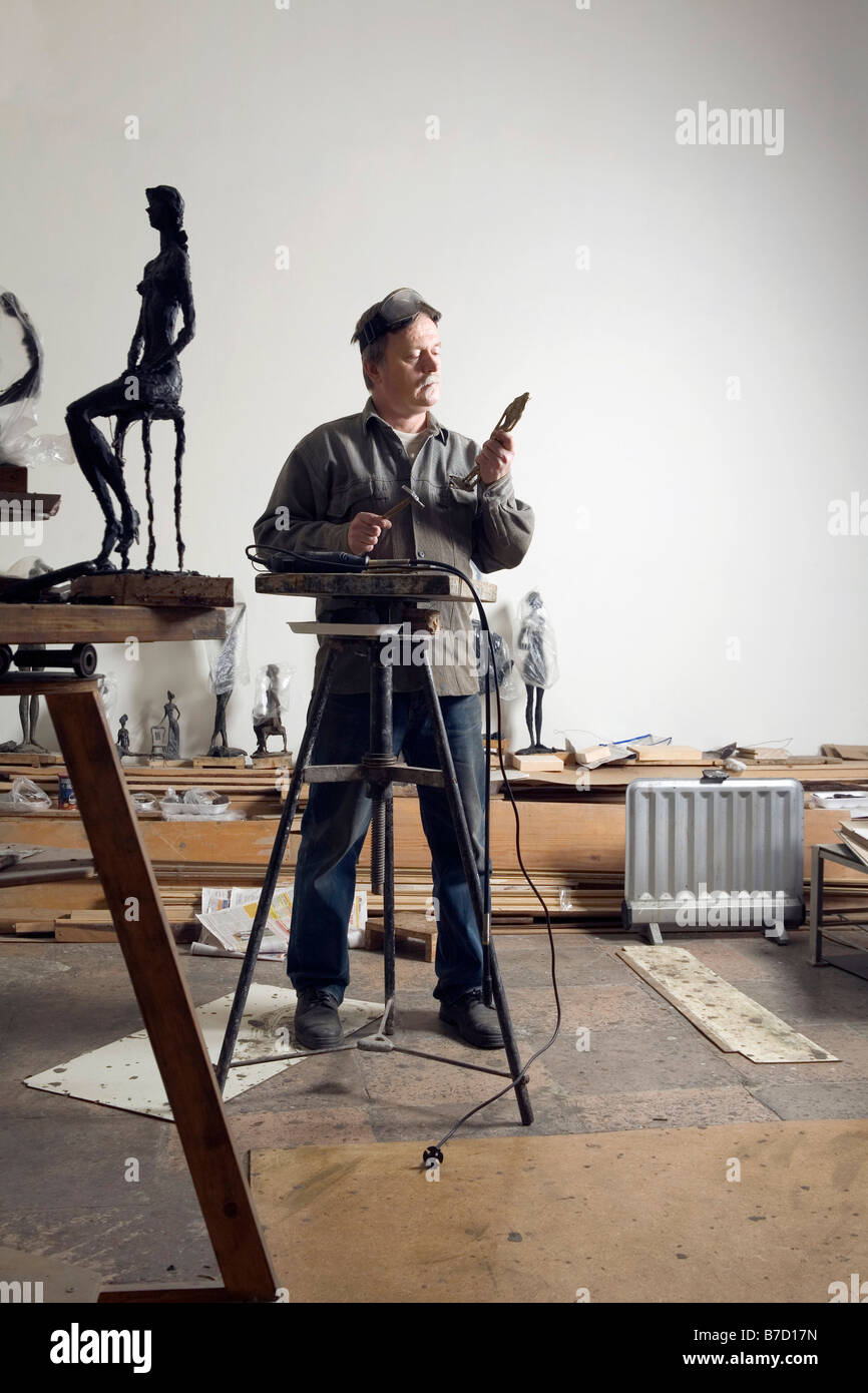 Uno scultore che lavorano in un'arte studio Foto Stock