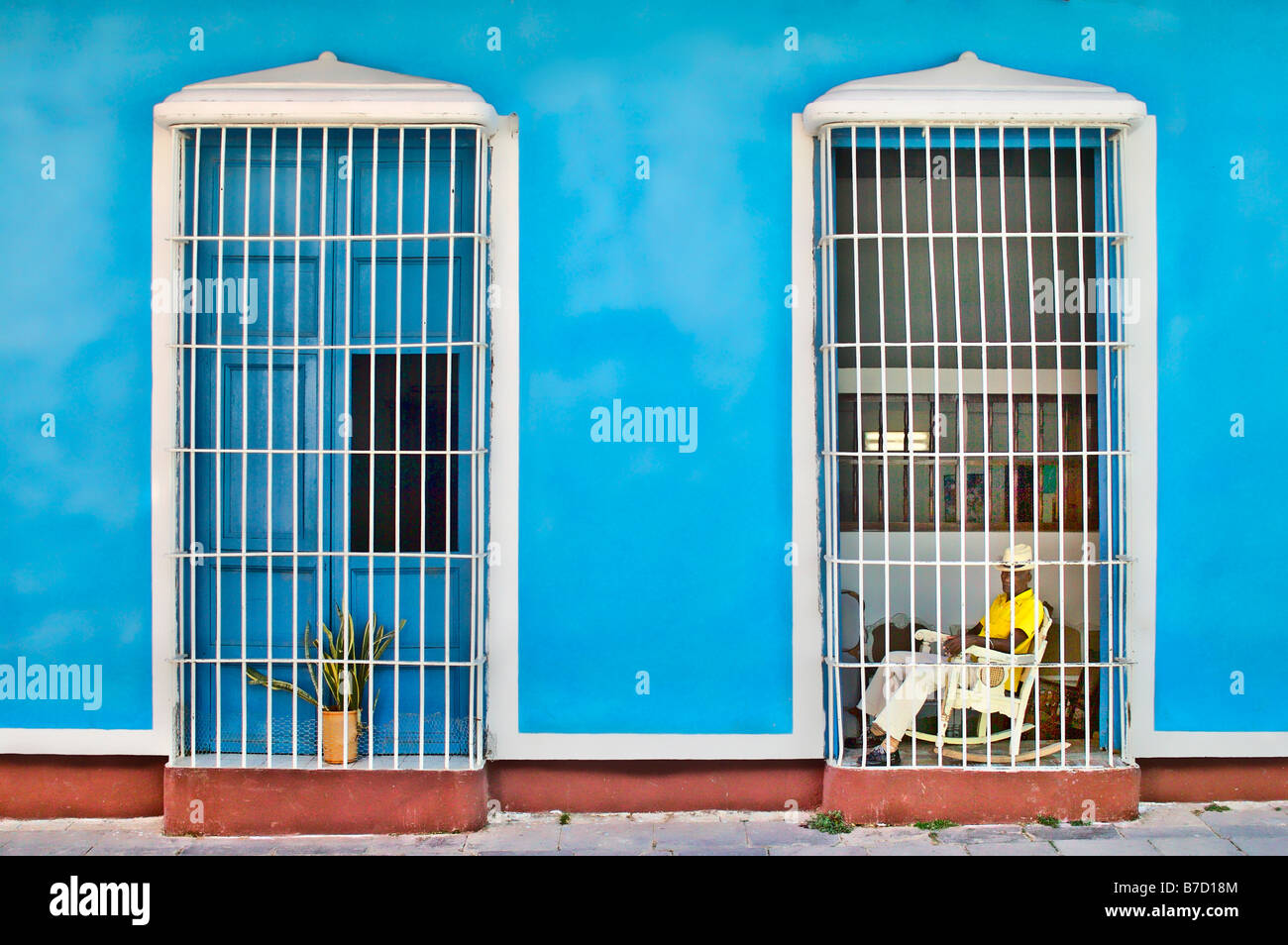 Uomo seduto dietro la finestra sbarrata Trinidad Cuba Foto Stock