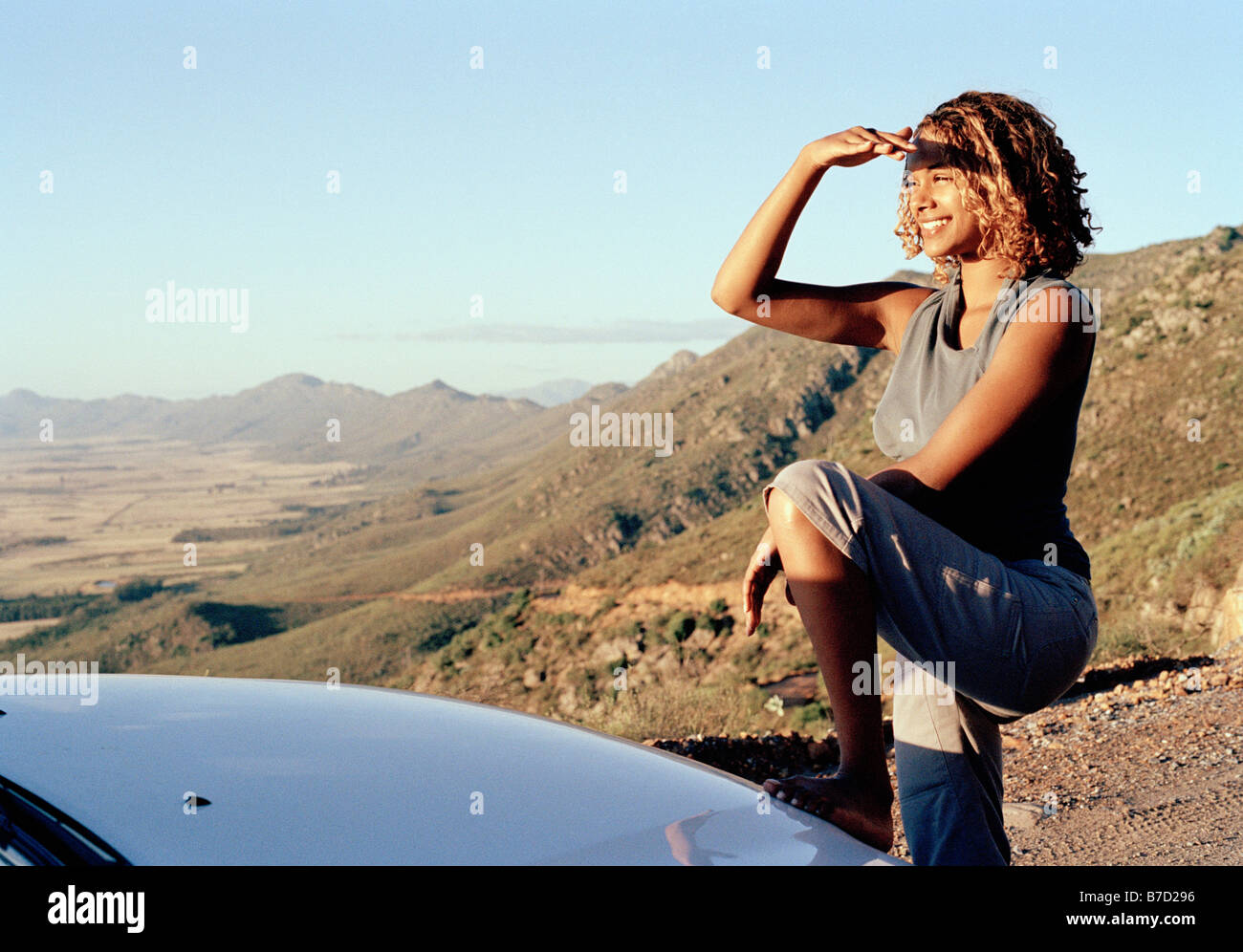 Una giovane donna che guarda attraverso un paesaggio arido Foto Stock