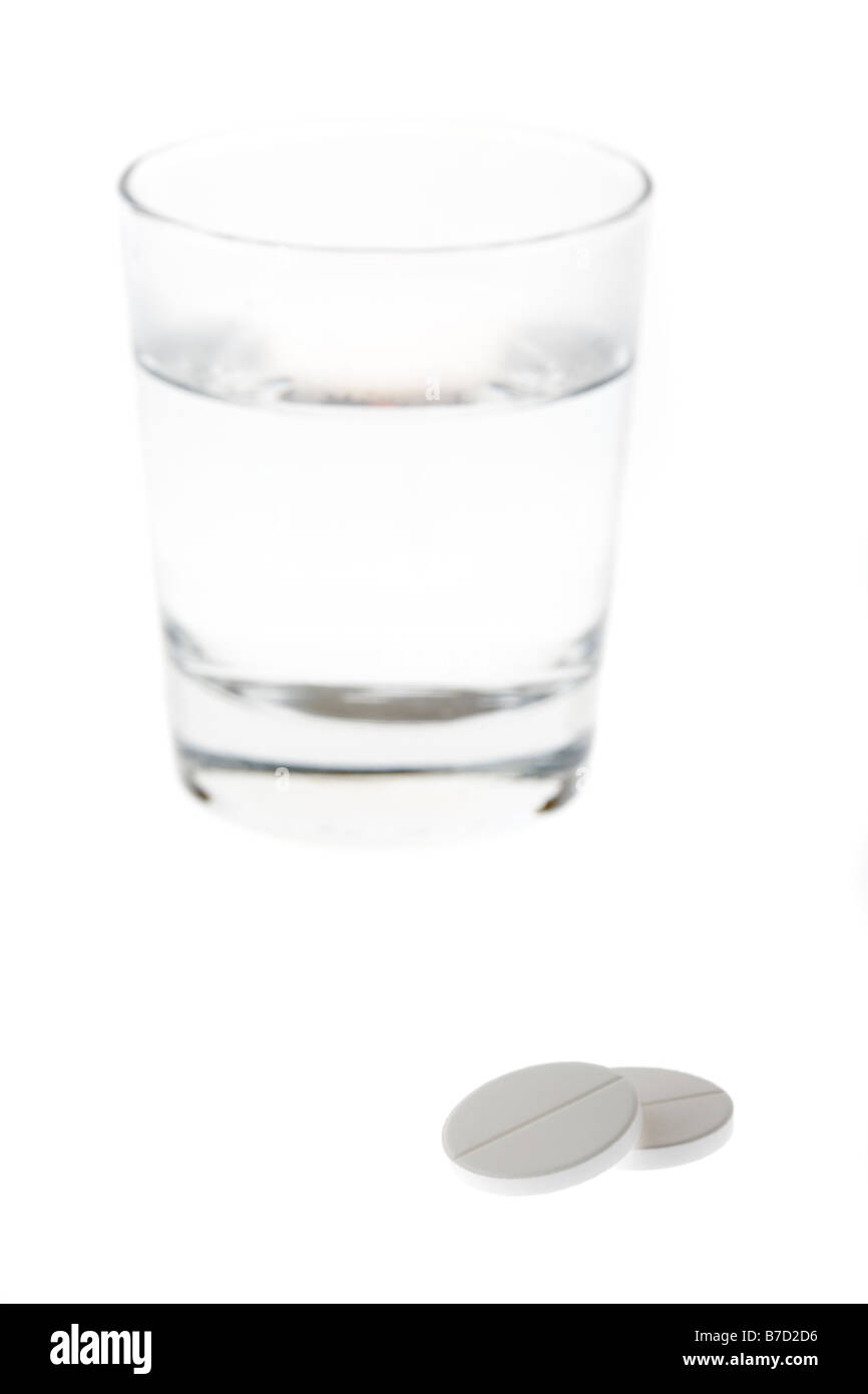 Bicchiere mezzo pieno vuoto con acqua con due grandi solubili di paracetamolo compresse isolati su sfondo bianco Foto Stock