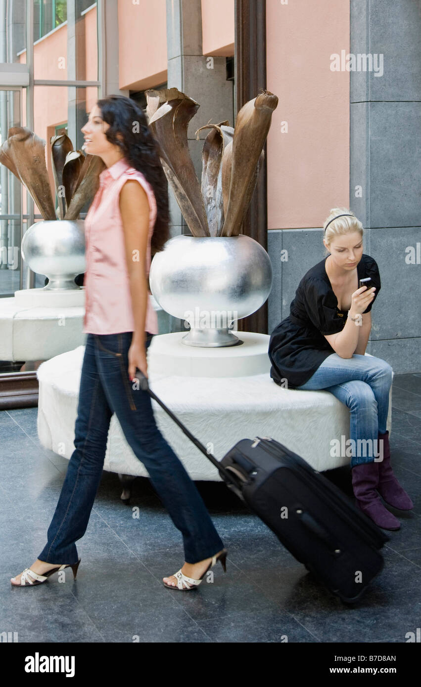 Le donne con i bagagli e il telefono cellulare Foto Stock