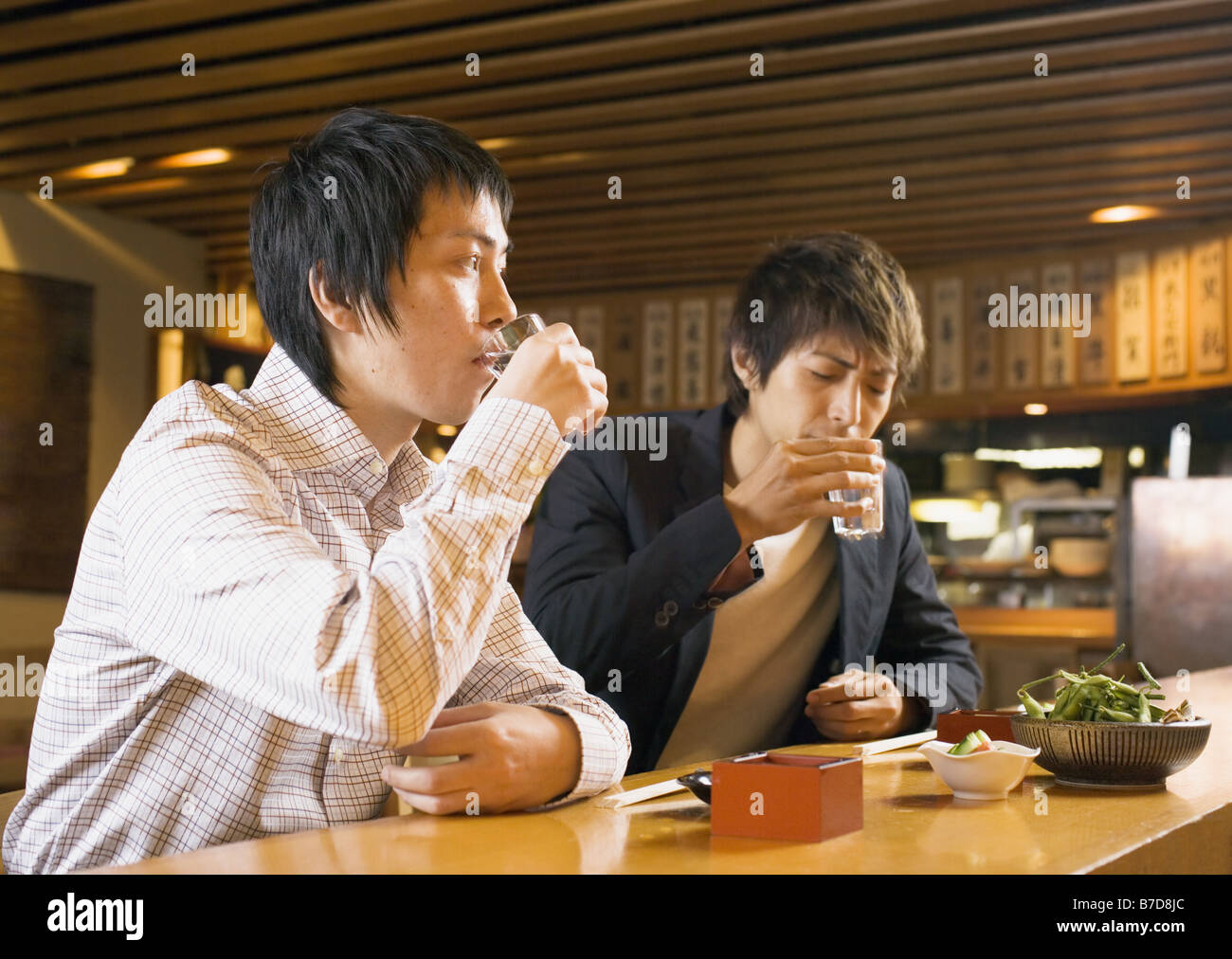 L'uomo avente un drink nel pub di stile Giapponese Foto Stock