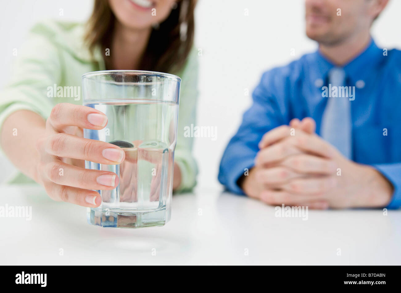 Donna di raggiungere per un bicchiere di acqua Foto Stock