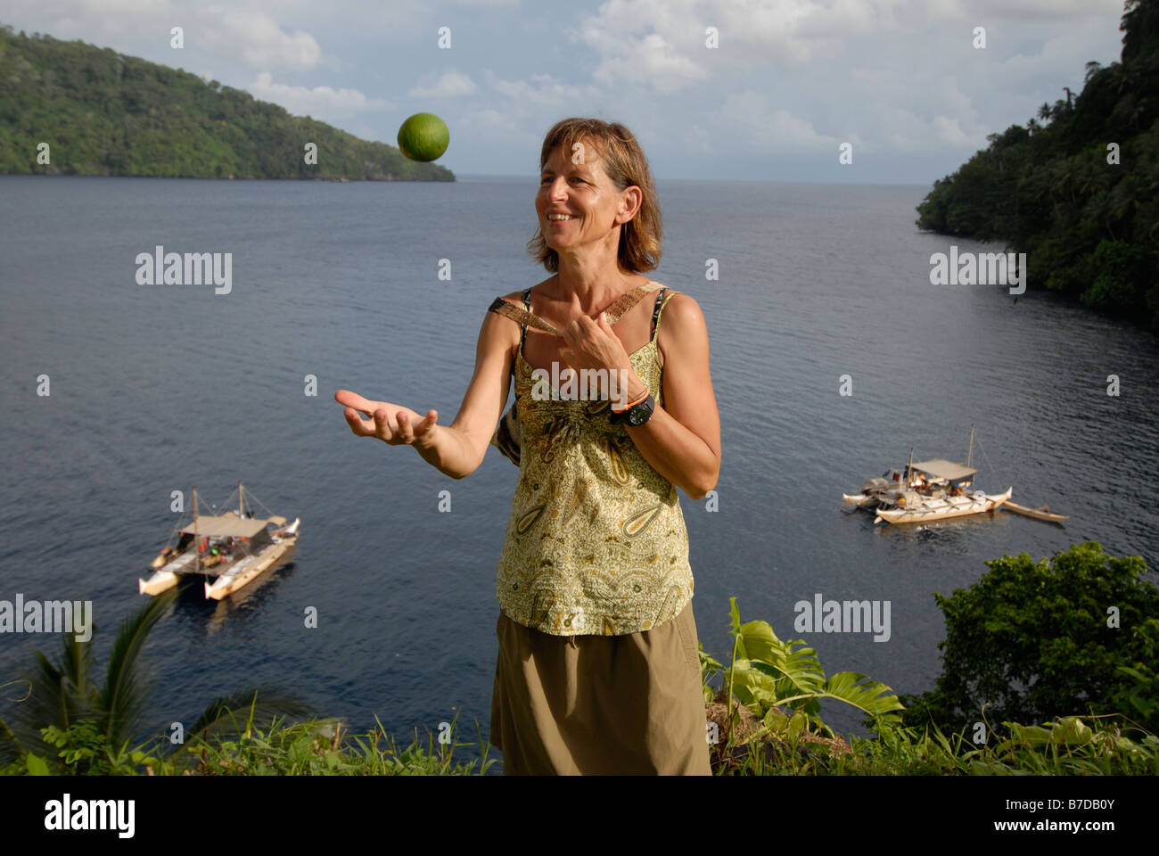 Donna gettando un limone in una baia in formato PNG. Papua Nuova Guinea. Foto Stock