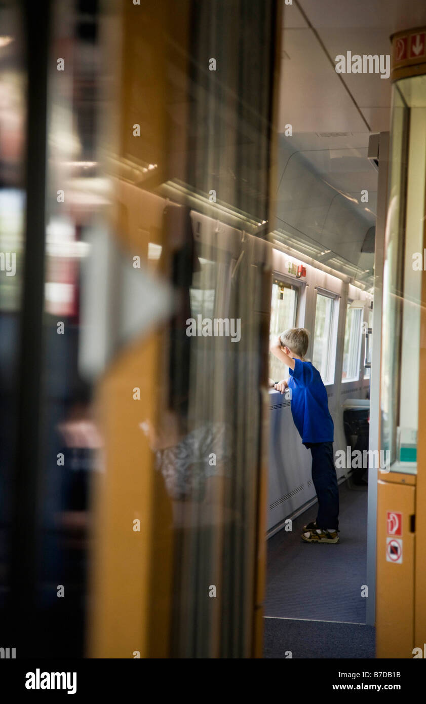 Ragazzo che guarda fuori la finestra del treno Foto Stock