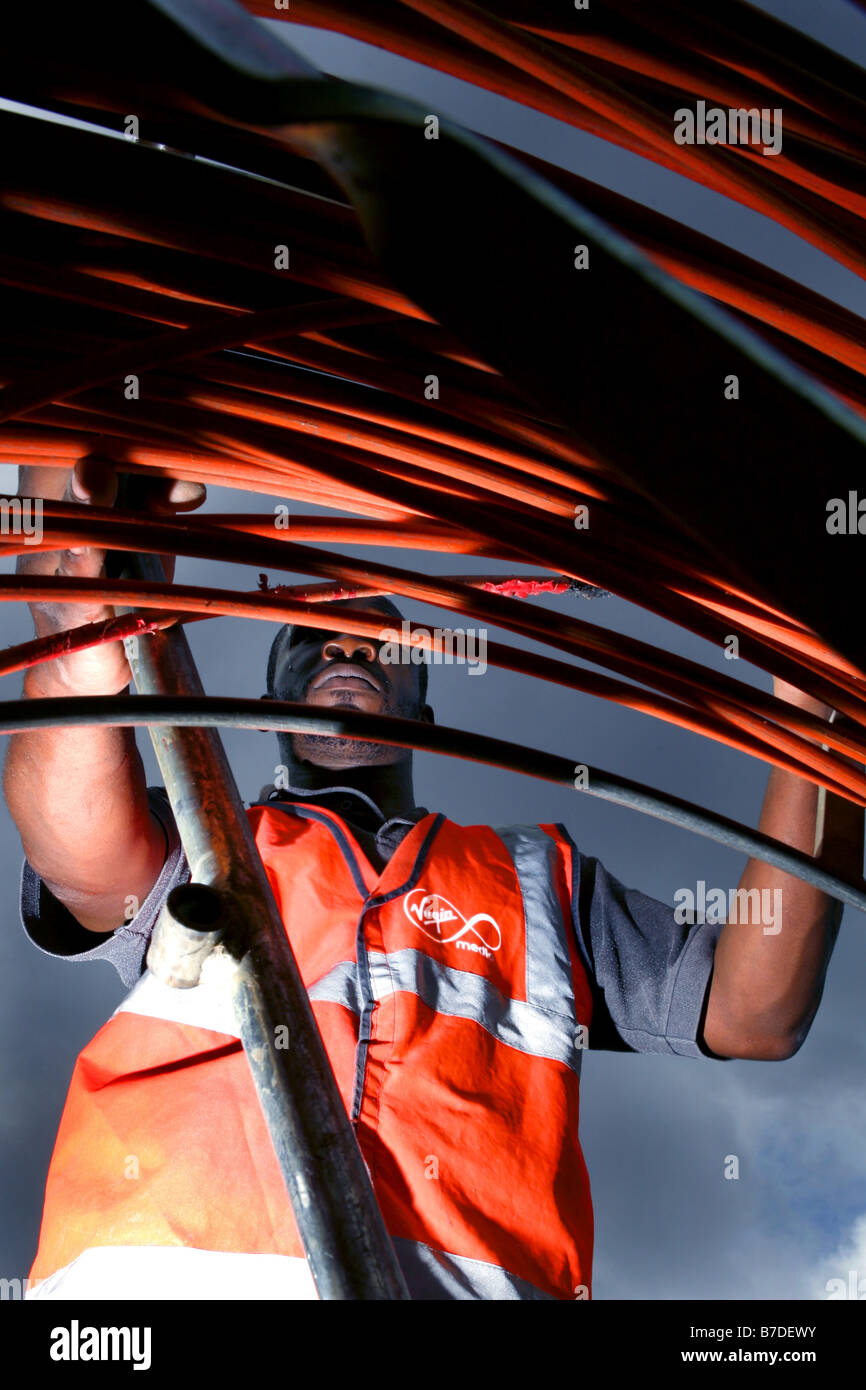 Virgin Mobile ingegneri il collegamento di una casa alla Vergine telefono internet e rete televisiva via cavo nel Nord di Londra Foto Stock