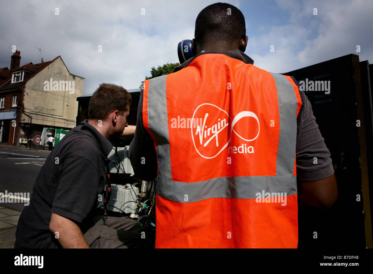 Virgin Mobile ingegneri il collegamento di una casa alla Vergine telefono internet e rete televisiva via cavo nel Nord di Londra Foto Stock