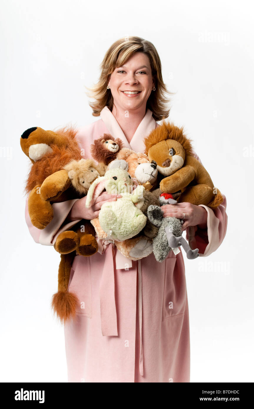Donna incinta in accappatoio rosa con giocattoli imbottiti Foto Stock