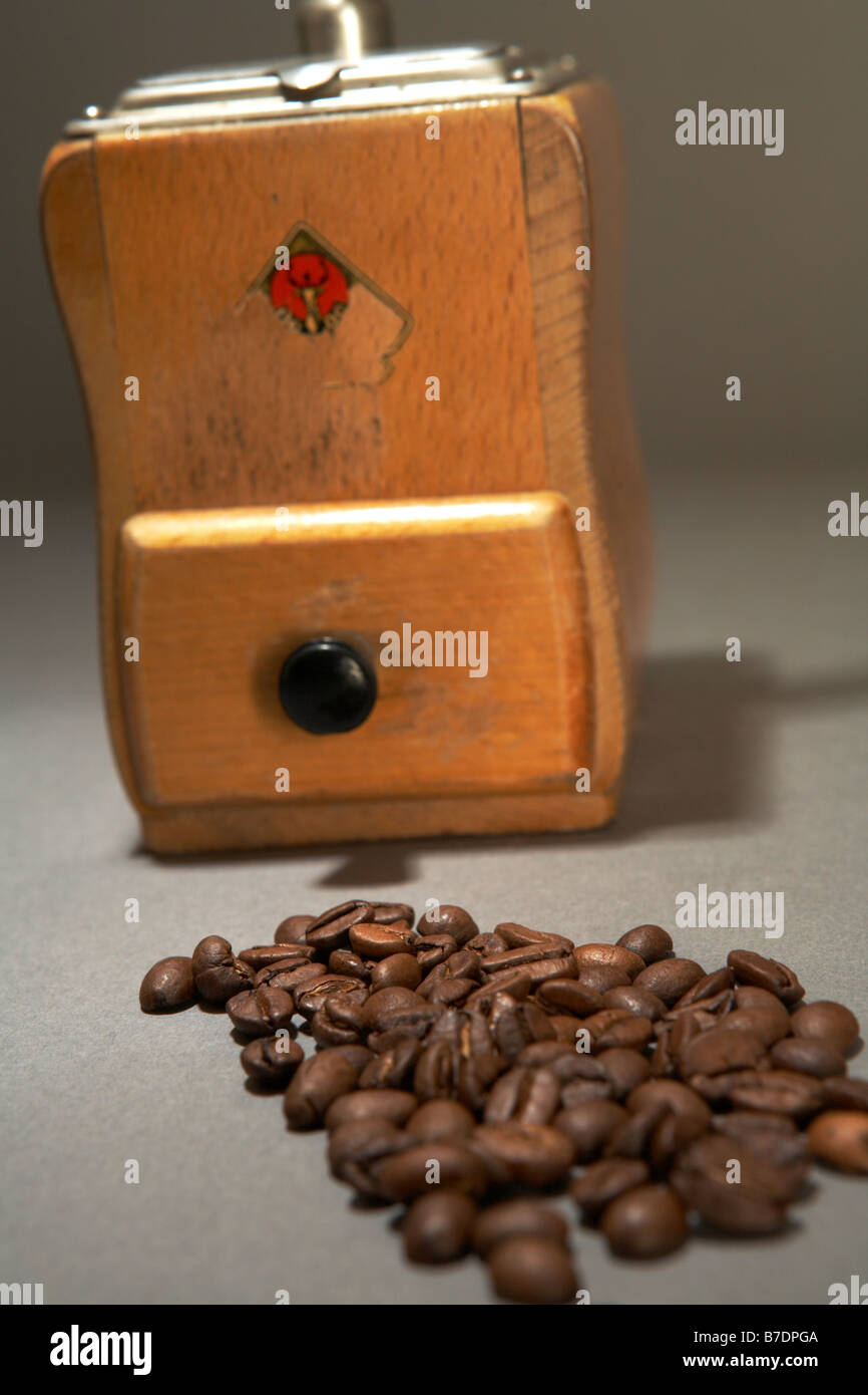 Legno macinino da caffè con cassetto e maniglia. I chicchi di caffè in primo piano. Foto Stock