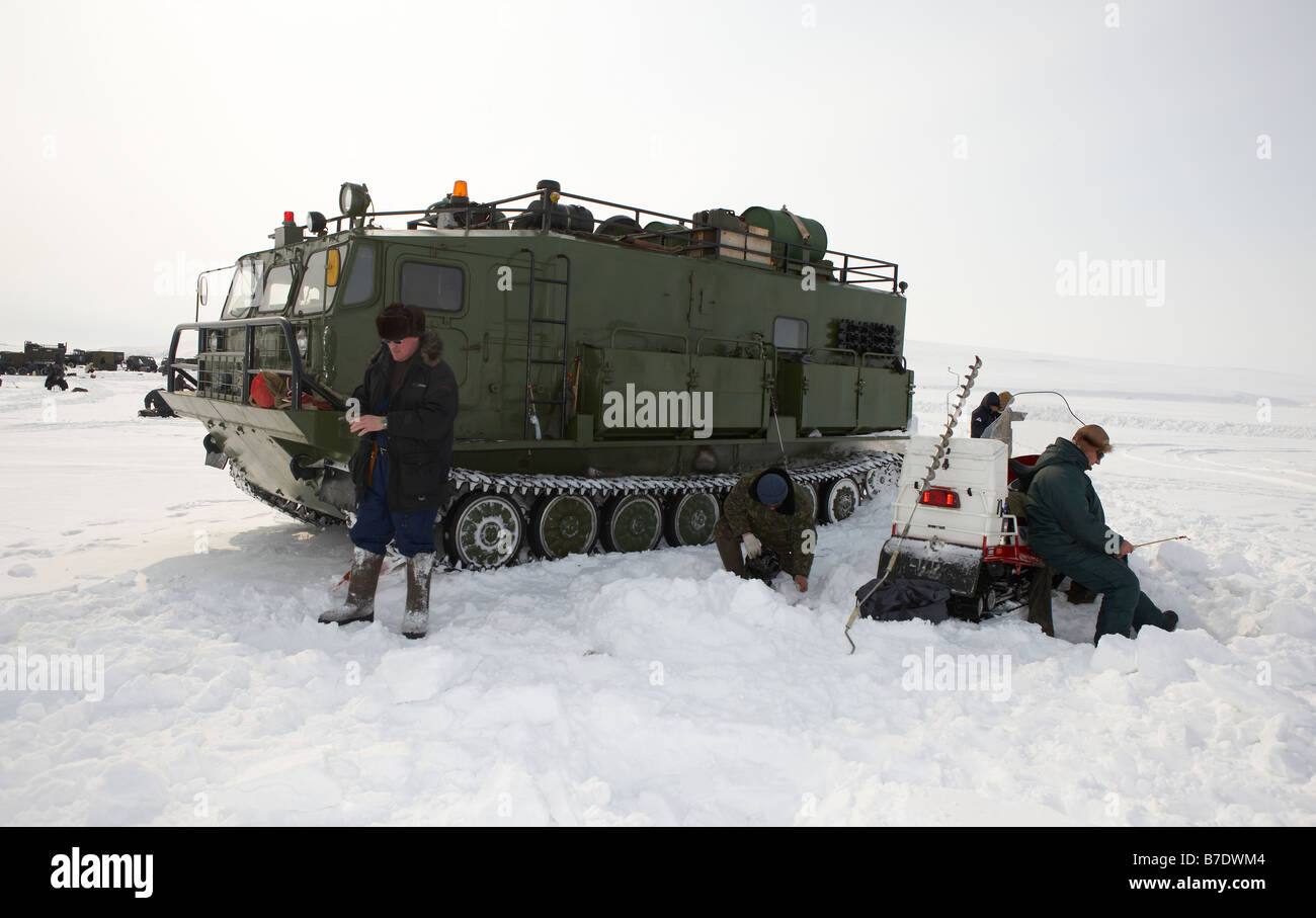 Pesca sul ghiaccio per smelleds nella parte anteriore del serbatoio modificato, (Vezdekhod) Anadyr Chukotka, Siberia, Russia Foto Stock