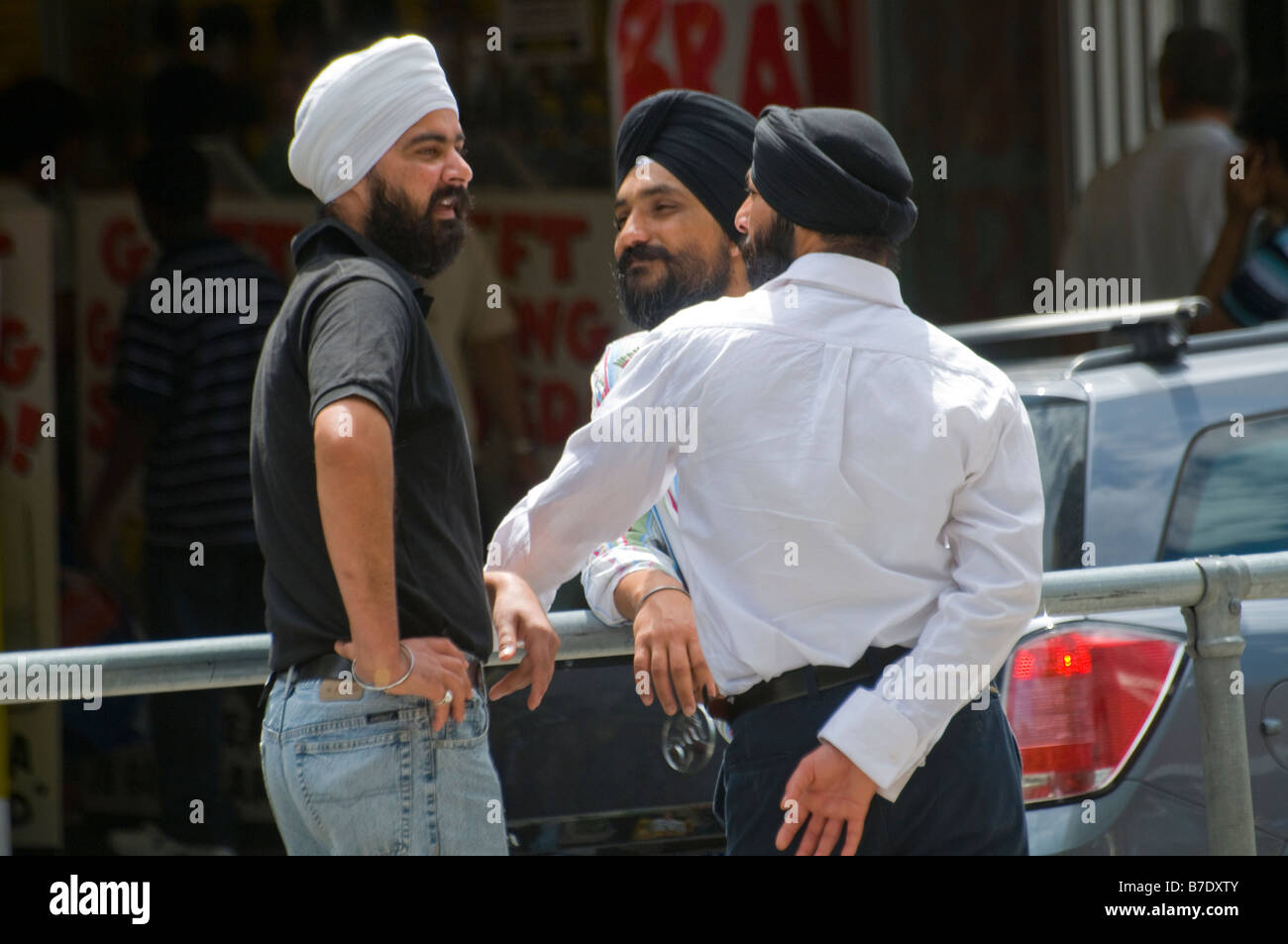 Tre immigrati indiani sikh in chat in strada a Melbourne in Australia Foto Stock