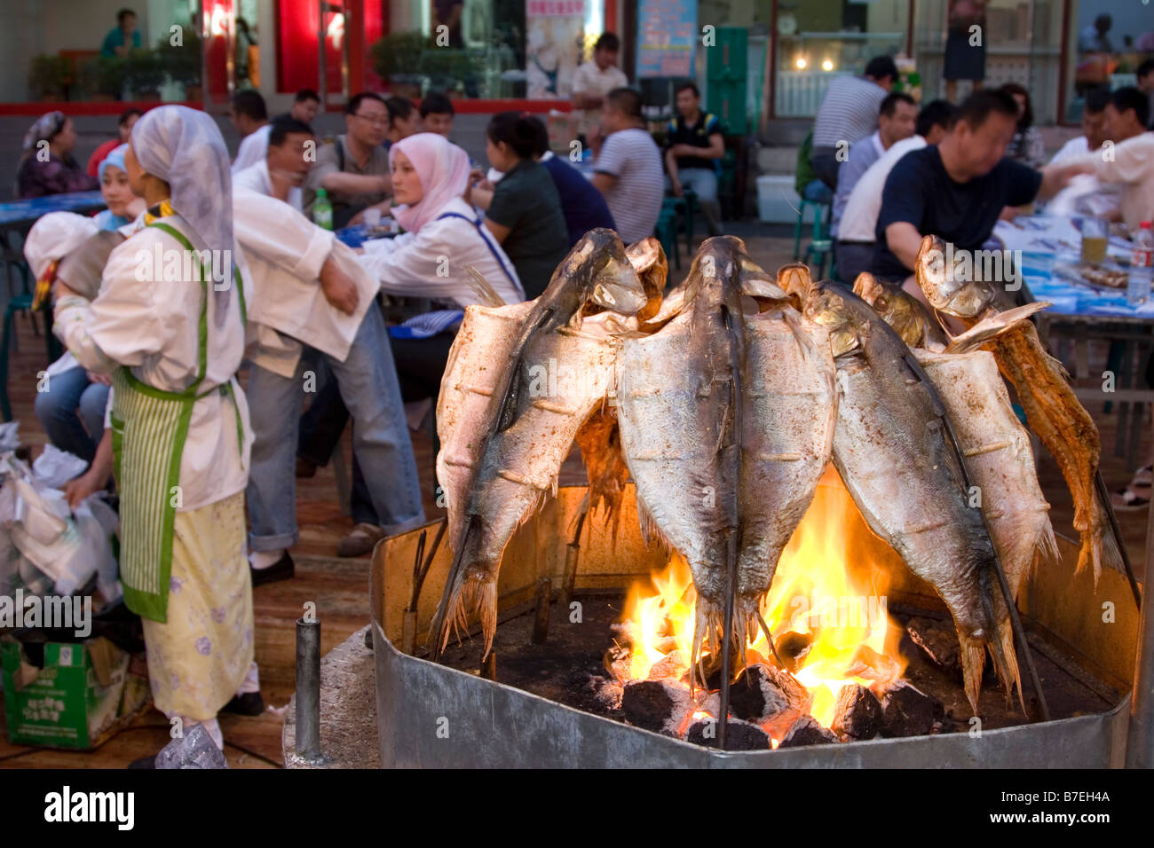 Grigliare il pesce al mercato notturno in Urumqi nel Xinjiang in Cina. Foto Stock