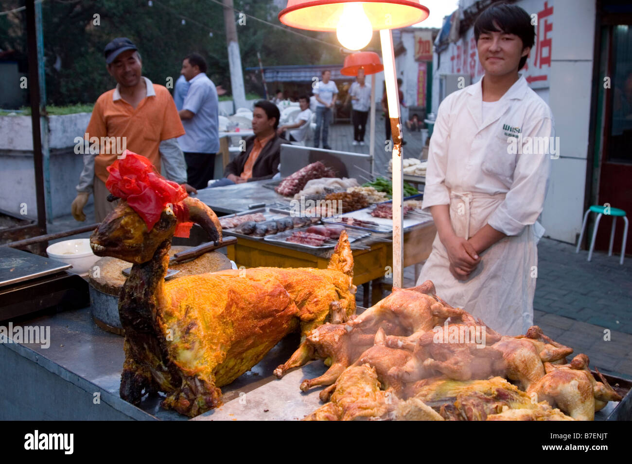 Arrosto di agnello al mercato notturno in Urumqi nella provincia dello Xinjiang in Cina. Foto Stock