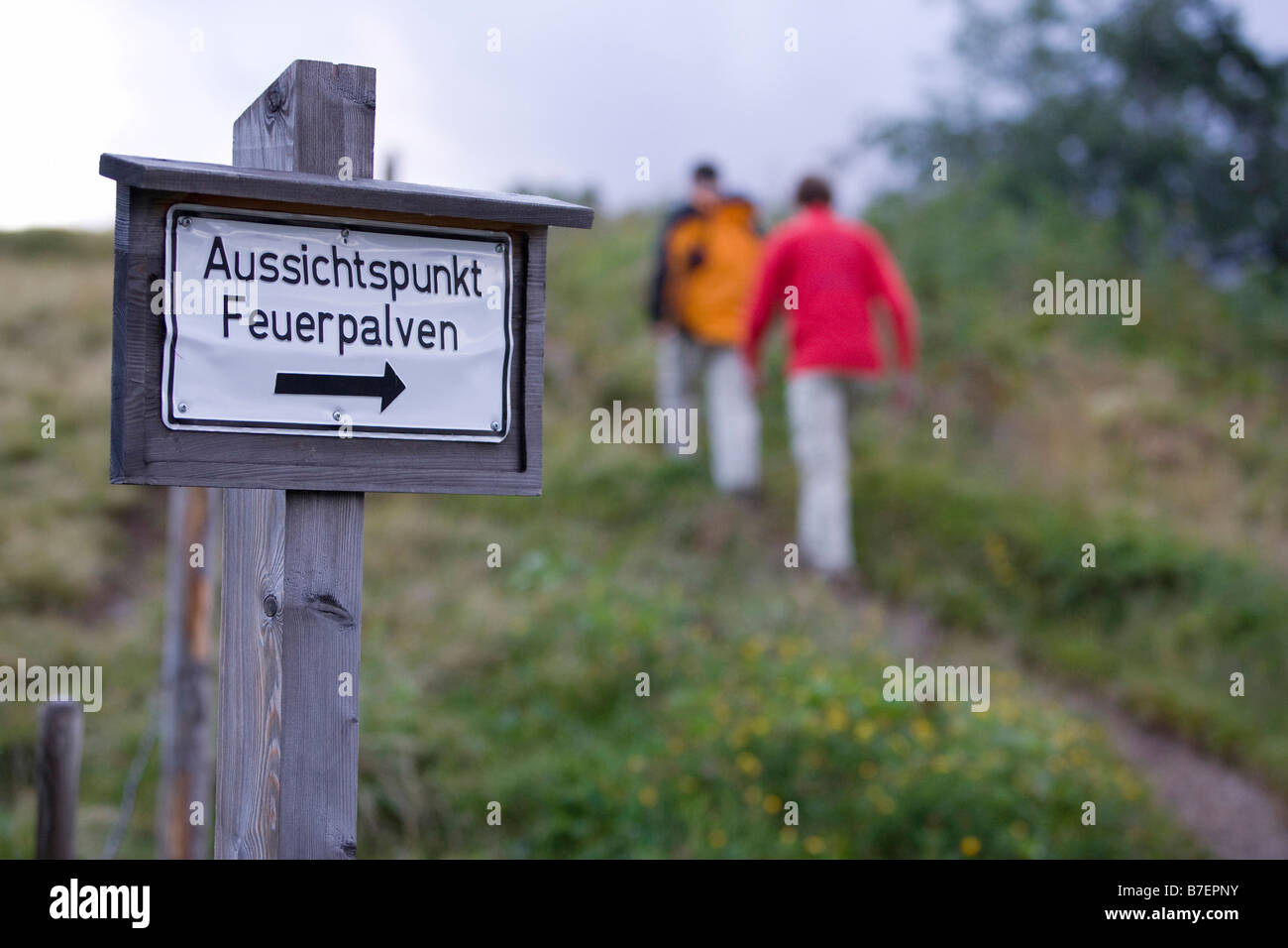 Cartello per vantage Feuerpalven e tre escursionisti vicino Koenigssee sulle Alpi di Berchtesgaden Germania Agosto 2008 Foto Stock