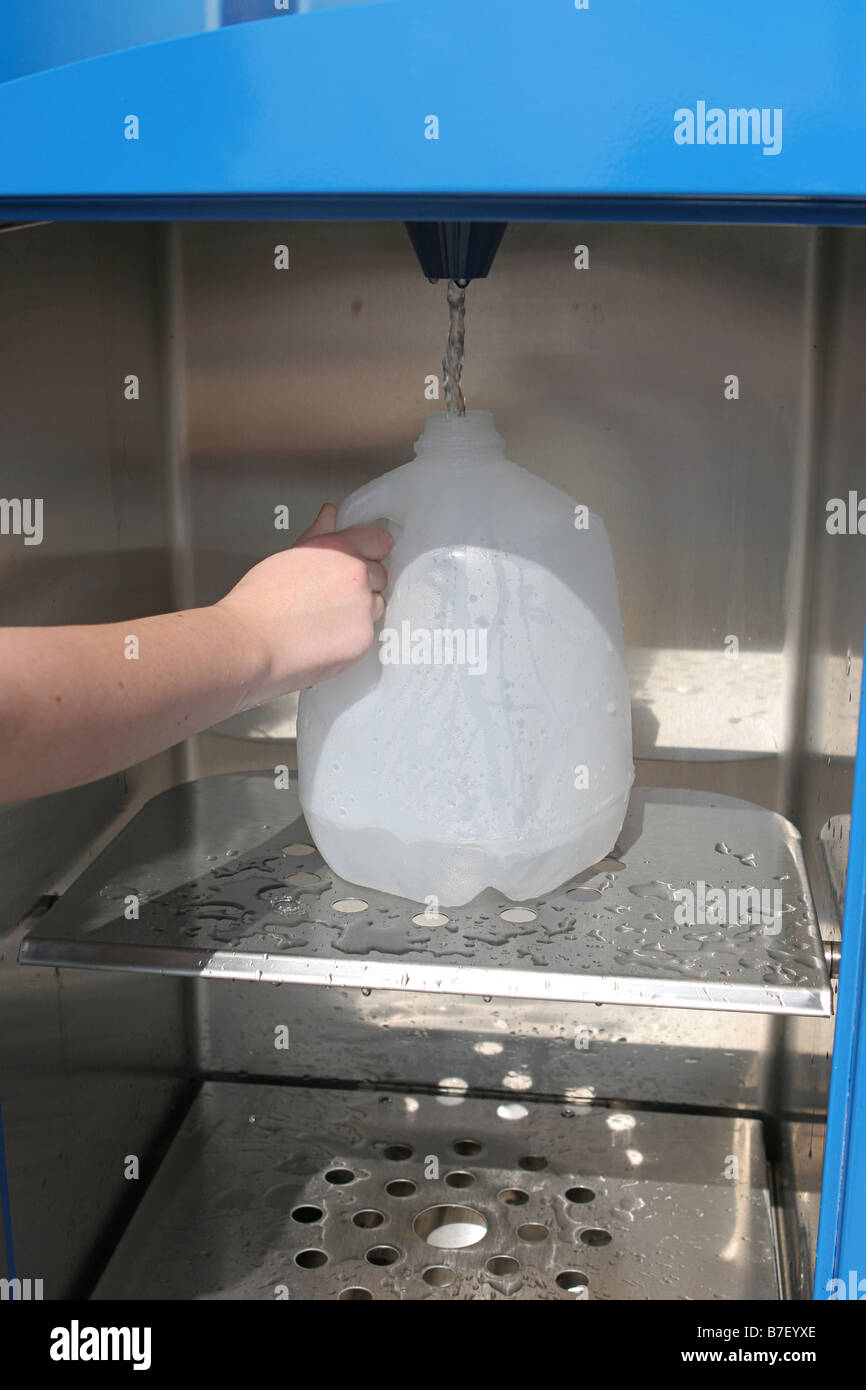 Un primo piano di una ragazza s ricarica a mano una brocca di acqua in preparazione per un uragano potrebbe anche essere usato per il riciclaggio Foto Stock