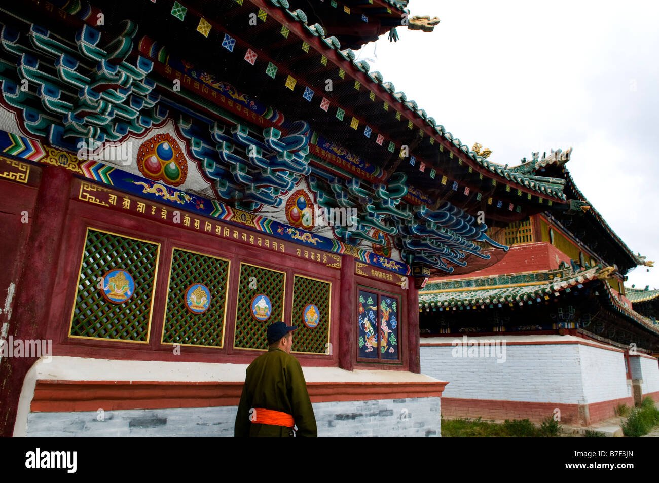 Un uomo mongolo passeggiate acquistare uno dei templi presso il famoso Erdene Zuu tempio complesso che è the1st monastero Buddista in Mongolia Foto Stock