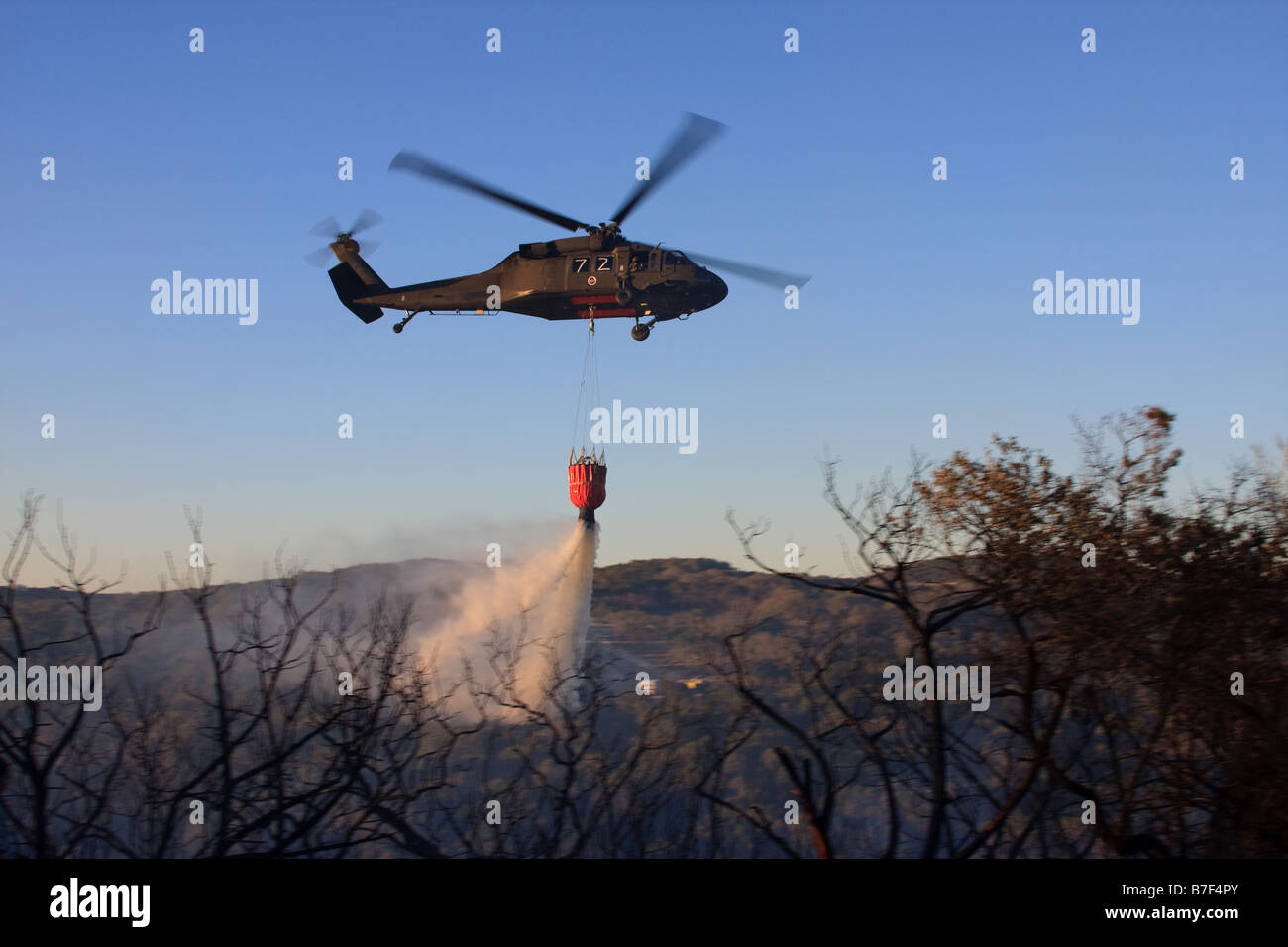 Sikorsky UH-60 Black Hawk elicottero acqua di dumping su un incendio. Foto Stock