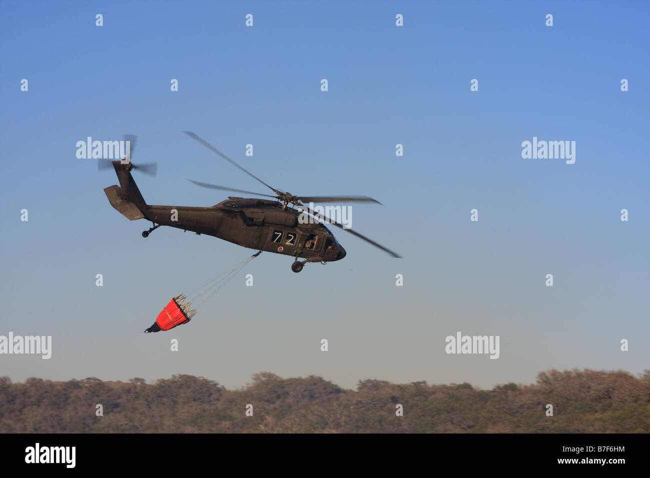 Sikorsky UH-60 Black Hawk elicottero preparando per eseguire il dump di acqua su un incendio. Foto Stock